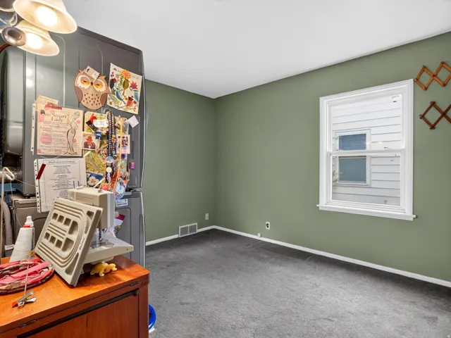 Single pane window with white trim, wall-to-wall carpeting, and neutral wall color