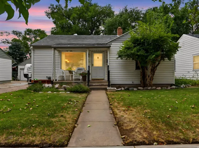 Charming cottage-style home featuring a welcoming front facade with large picture windows, horizontal siding exterior, and a covered entry porch
