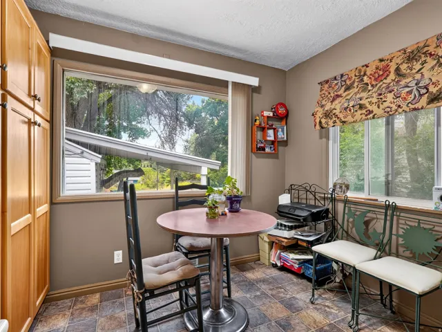 Wood-finish cabinetry, tile-patterned flooring, and a large window