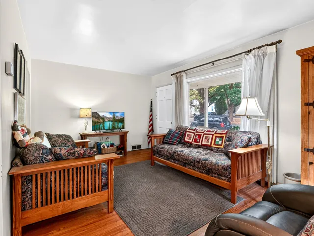 Hardwood flooring, recessed lighting, white trim, and a large window