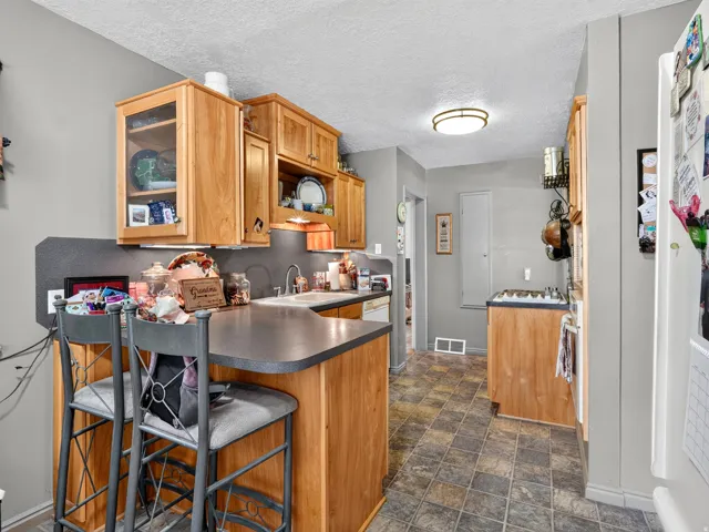 Kitchen featuring light wood cabinetry, a built-in breakfast bar, a gas range, and tiled flooring