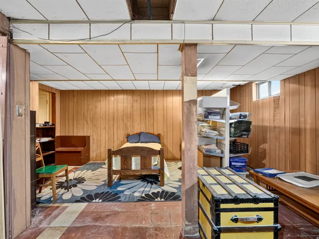 Finished room featuring wood-paneled walls and a drop ceiling