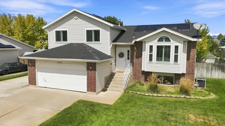 Two-story residence featuring light-colored siding and brick accents