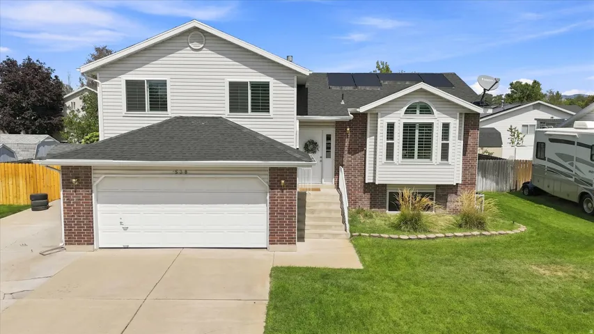 Two-story residence featuring a two-car garage, brick accents, and a bay window