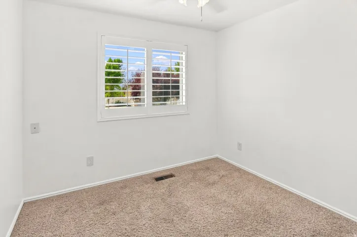 Bedroom #3.  White custom shutters.