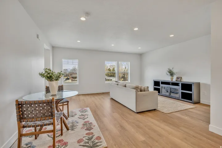 Spacious room featuring wood-finish flooring, recessed lighting, and multiple windows