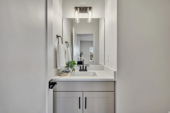 Vanity with an integrated rectangular sink, light-toned countertop, and modern black faucet