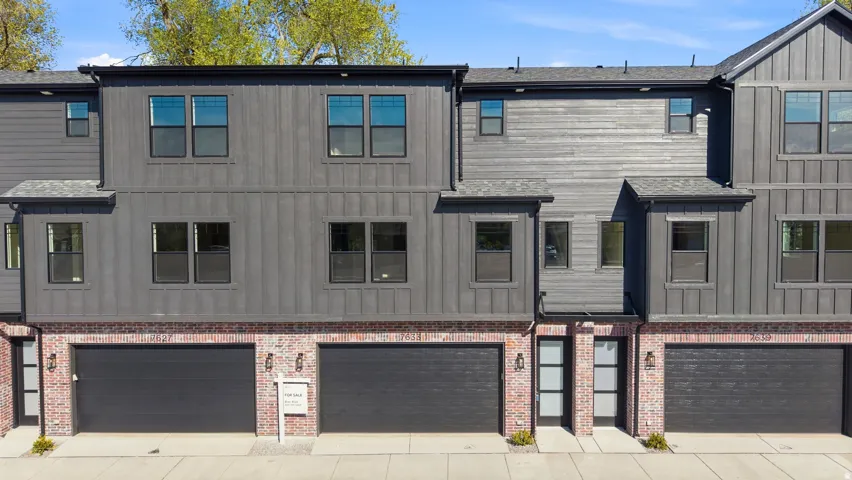 Contemporary exterior with dark siding and brick accents