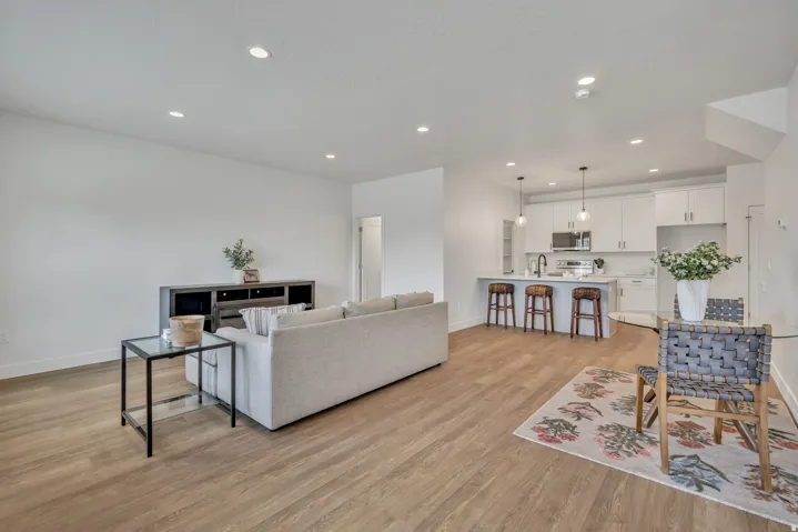 Open-concept living area featuring wood-finish flooring, recessed lighting, and white walls