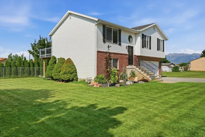 Split-level residence featuring white siding and brick detailing