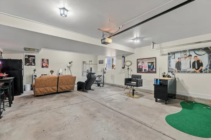 Finished concrete flooring in a spacious room with recessed lighting and a built-in overhead garage door track system