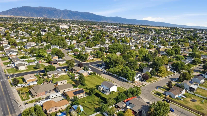 Residential neighborhood with mature trees, established street grid, and distant mountain range
