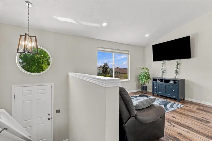 Wood-finish flooring, recessed lighting, and a contemporary hanging light fixture