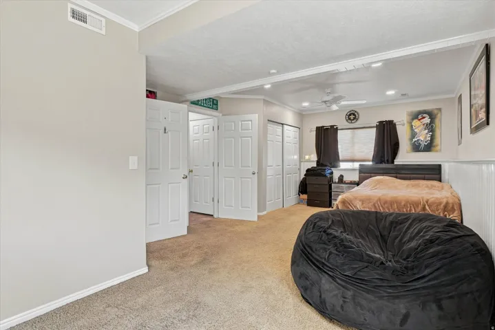 Carpeted flooring, crown molding, white trim, recessed lighting, and a ceiling fan