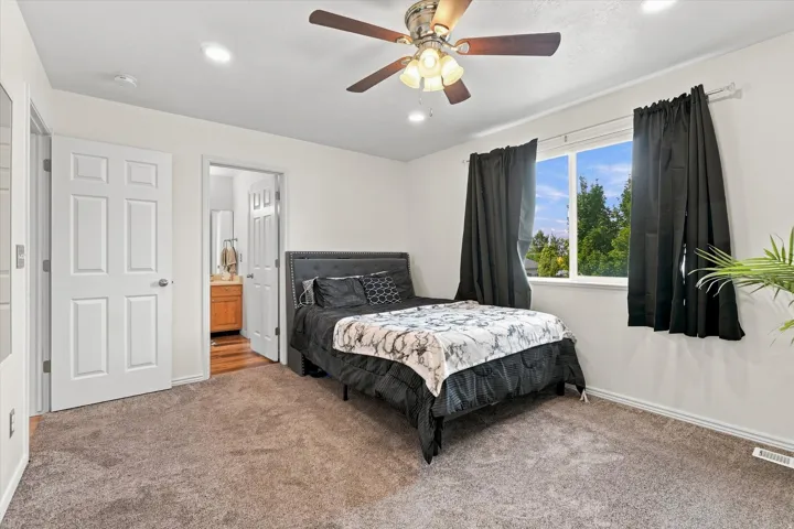 Textured carpeting, white walls, and a ceiling fan with integrated lighting