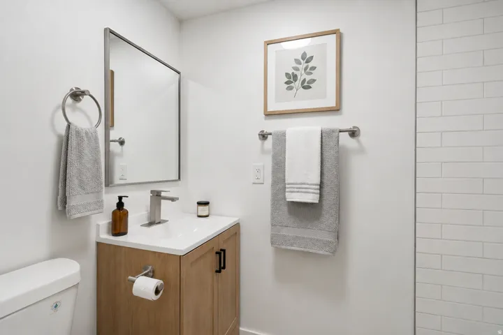 Modern vanity with white countertop, chrome faucet, and rectangular mirror