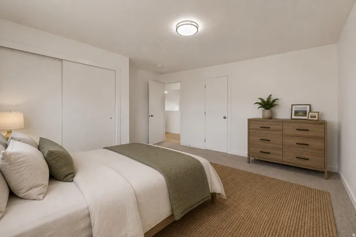 Neutral wall colors, recessed lighting, sliding closet doors, and carpeted flooring