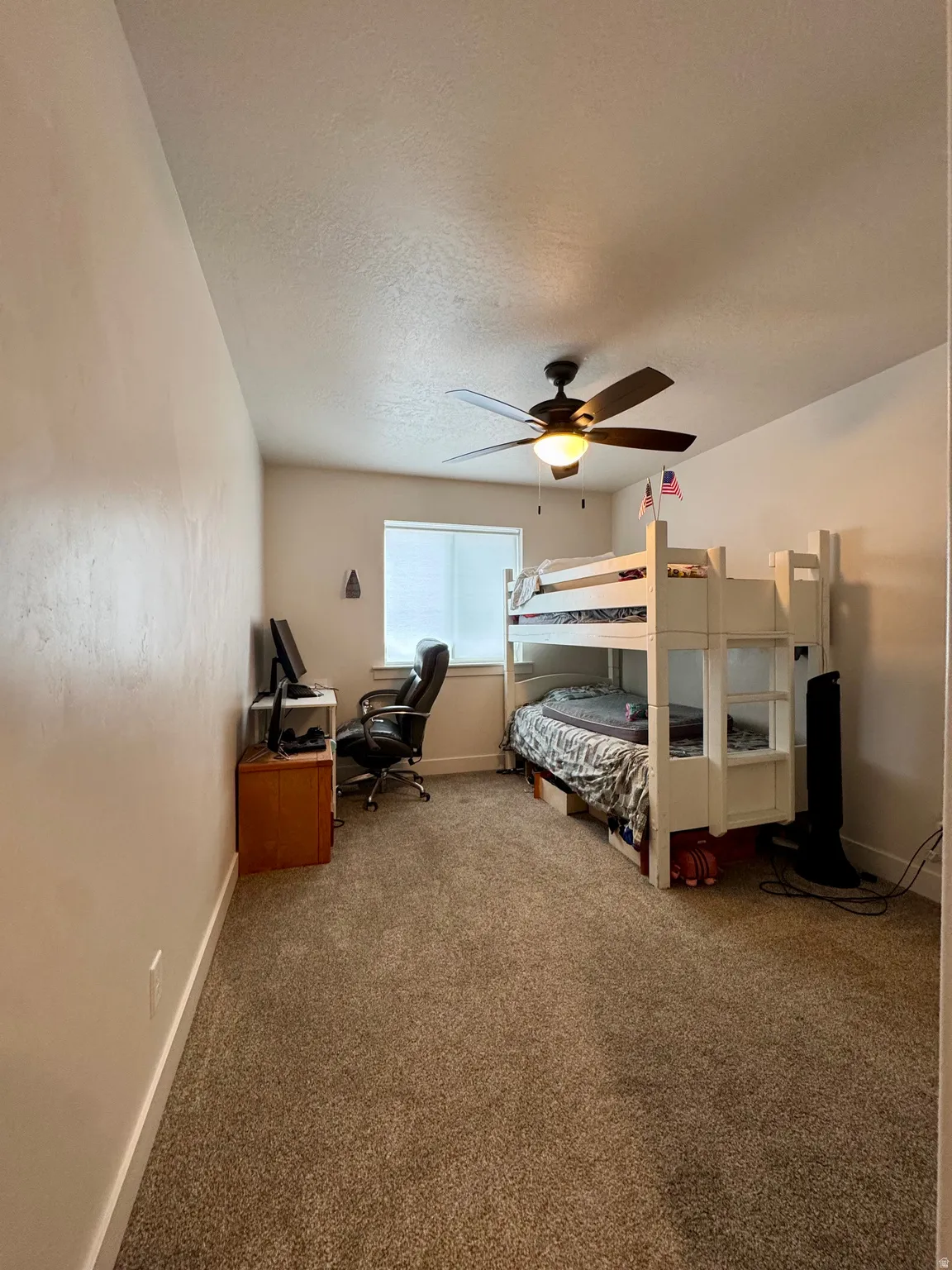 Carpeted flooring, a window with blinds, and a ceiling fan with integrated lighting