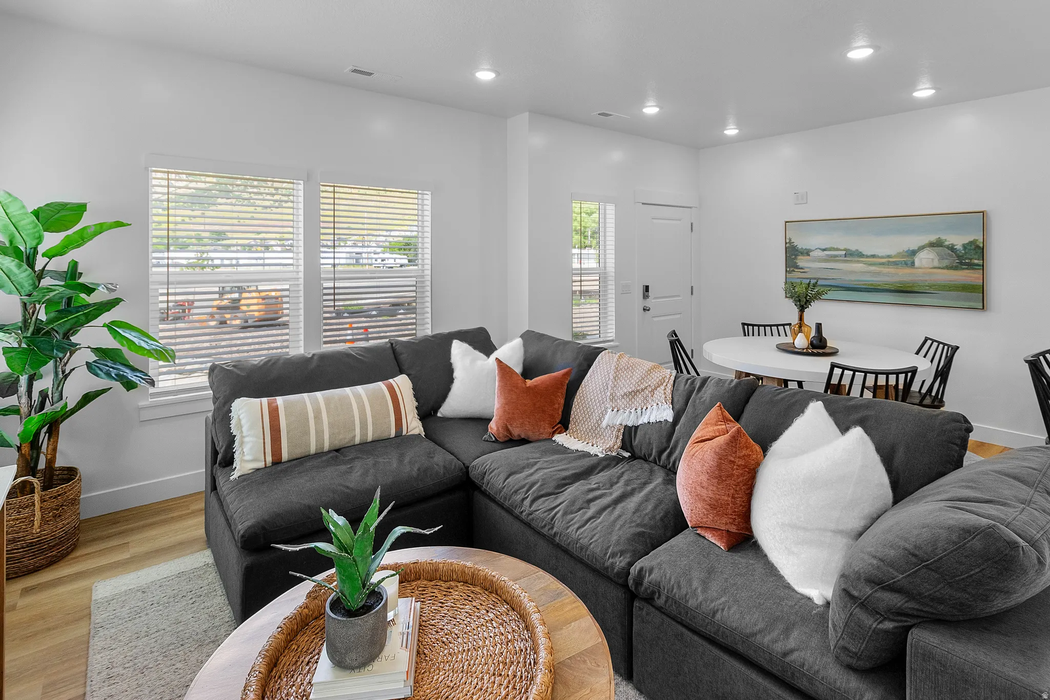 Recessed lighting, light wood-finish flooring, white walls, and multiple windows with blinds