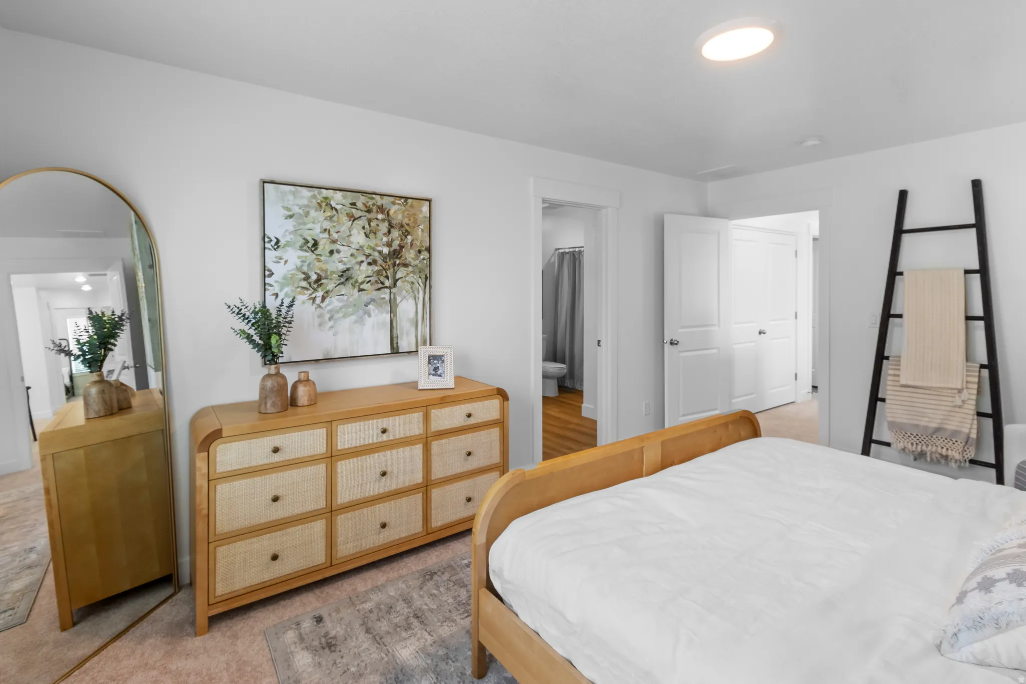 Recessed ceiling light, white painted walls, wood-finish flooring, white paneled doors, and a natural wood-finish dresser