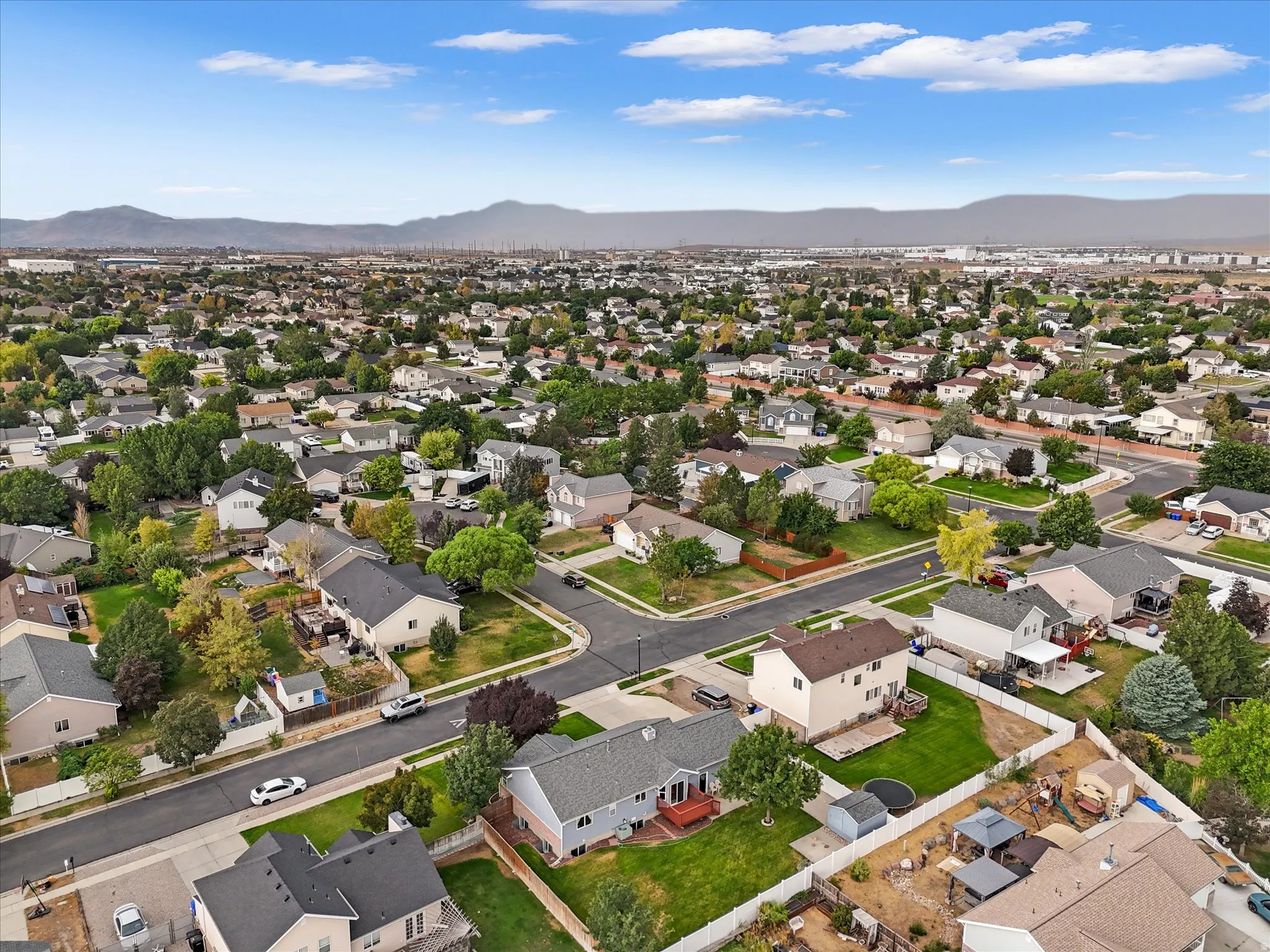 Residential neighborhood with mature trees and visible mountain range