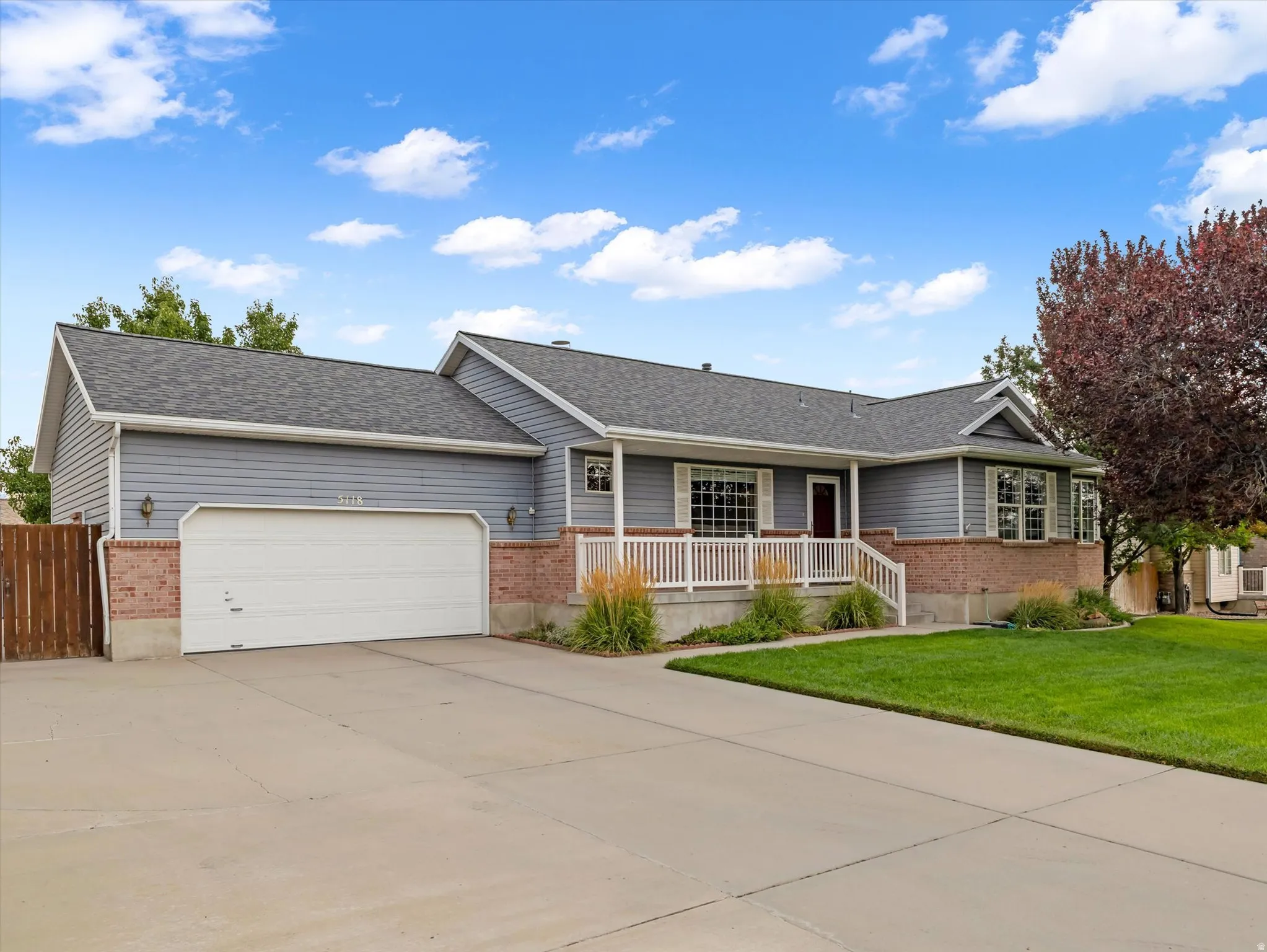 Ranch-style exterior with gray siding and brick accents