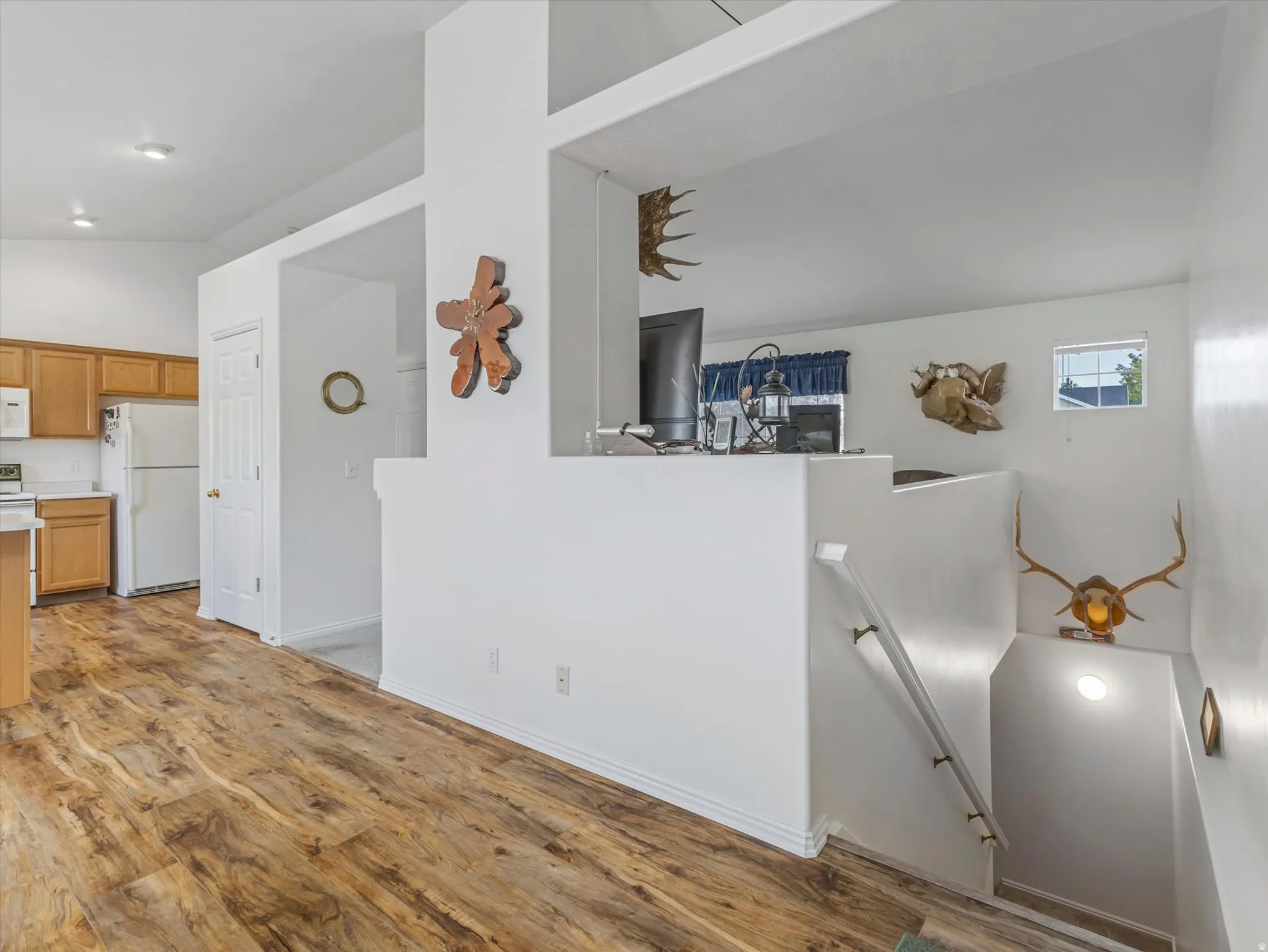 Wood-finish flooring throughout, white interior walls, and recessed lighting