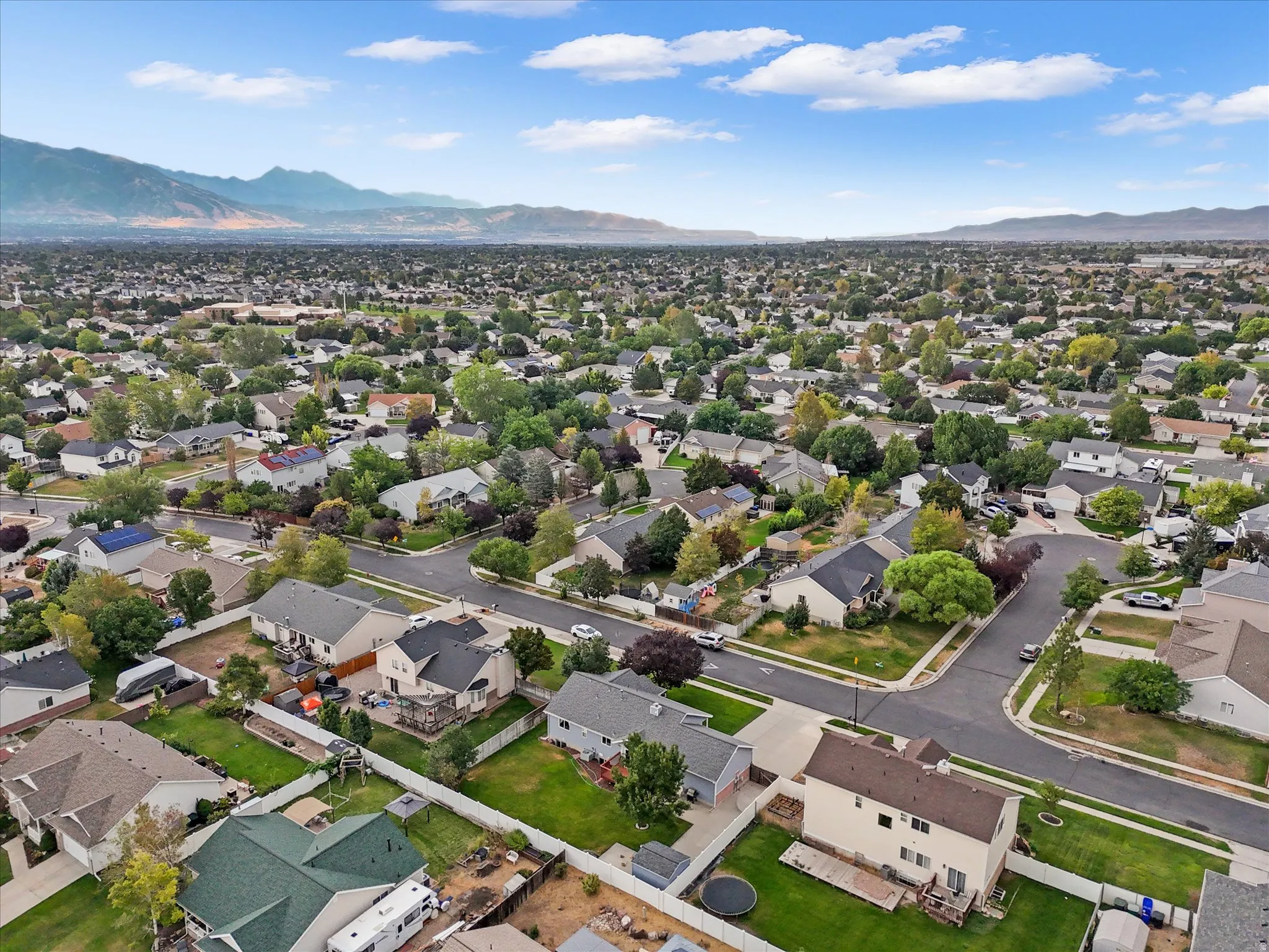 Expansive residential neighborhood with distant mountain backdrop, mature trees, and paved streets