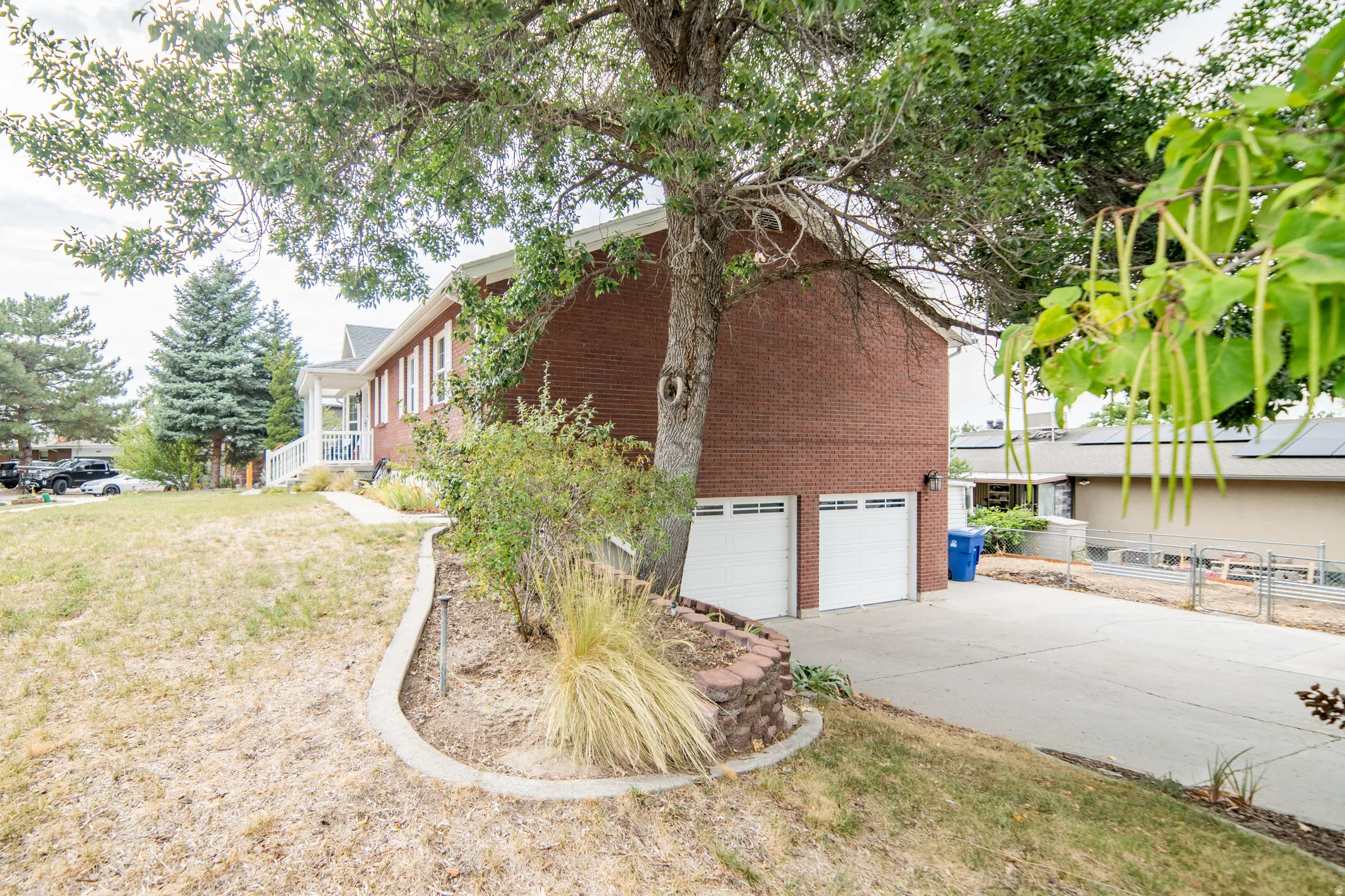 Brick exterior with white trim, two attached garage doors, and a concrete driveway