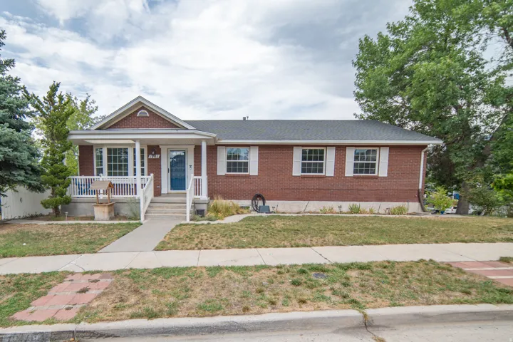 Brick exterior with white window shutters and a covered front porch featuring white railings