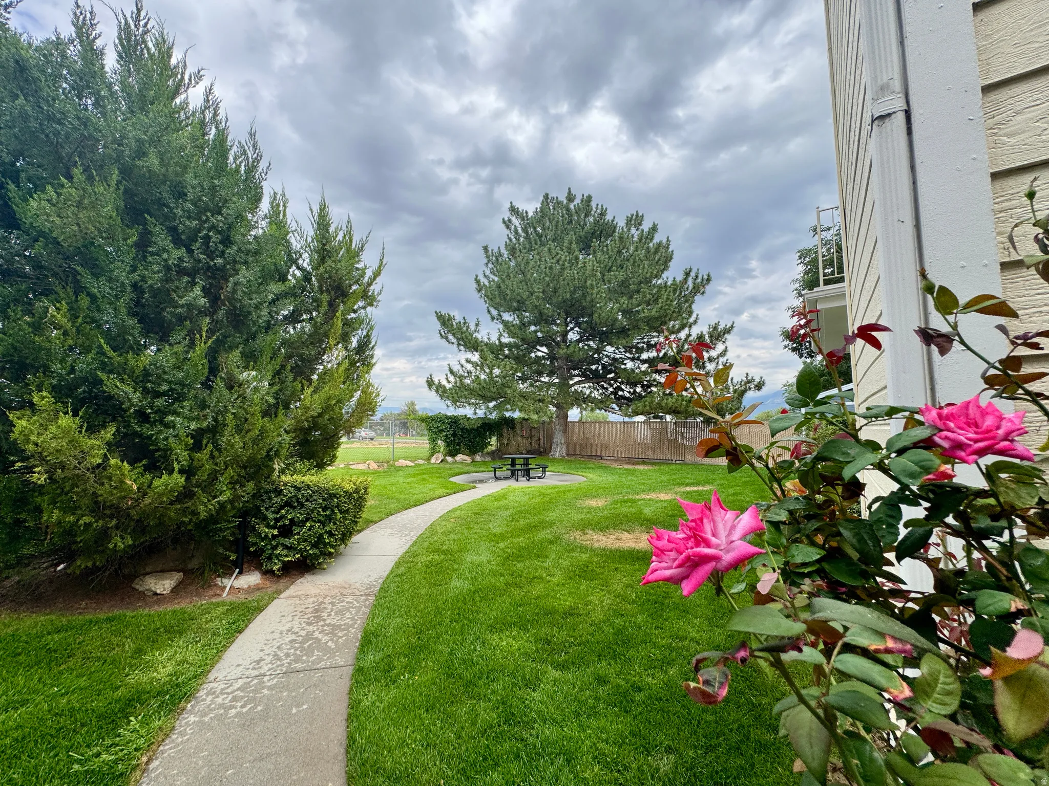 Expansive lawn featuring mature trees and established landscaping