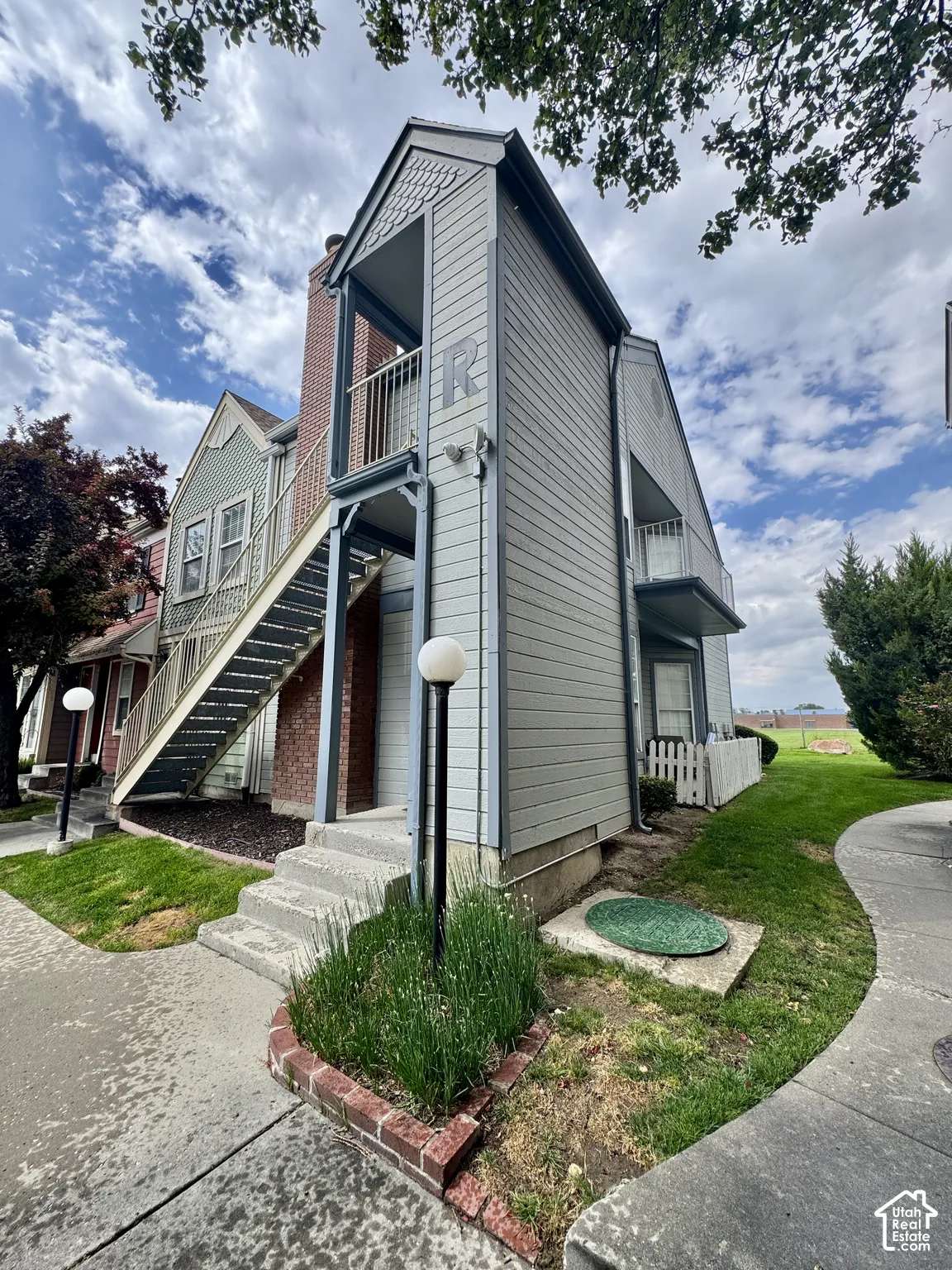 Multi-level siding exterior with exposed brick chimney and concrete stairs