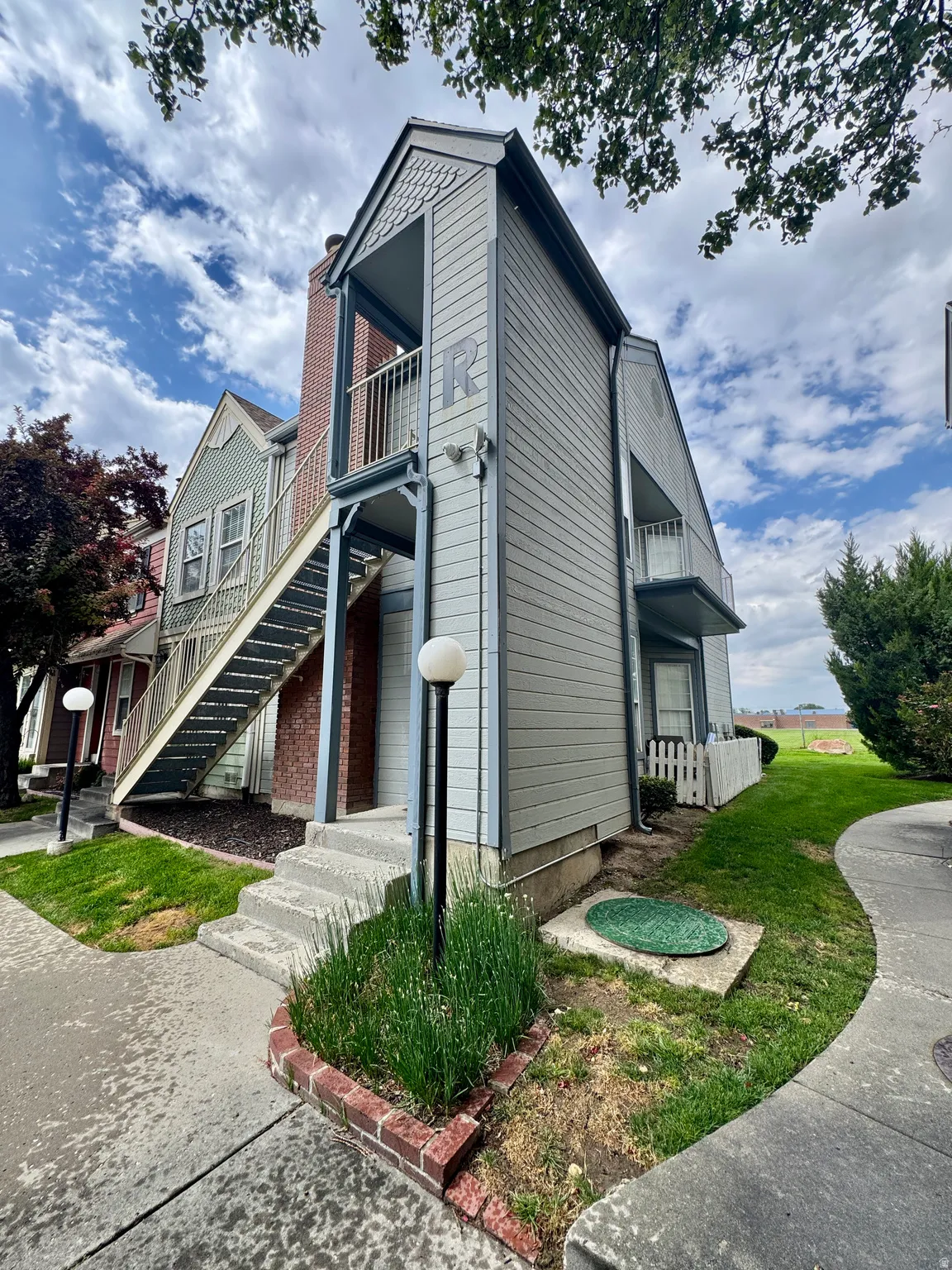 Multi-level siding exterior with exposed brick chimney and concrete stairs