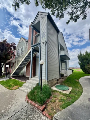 Multi-level siding exterior with exposed brick chimney and concrete stairs