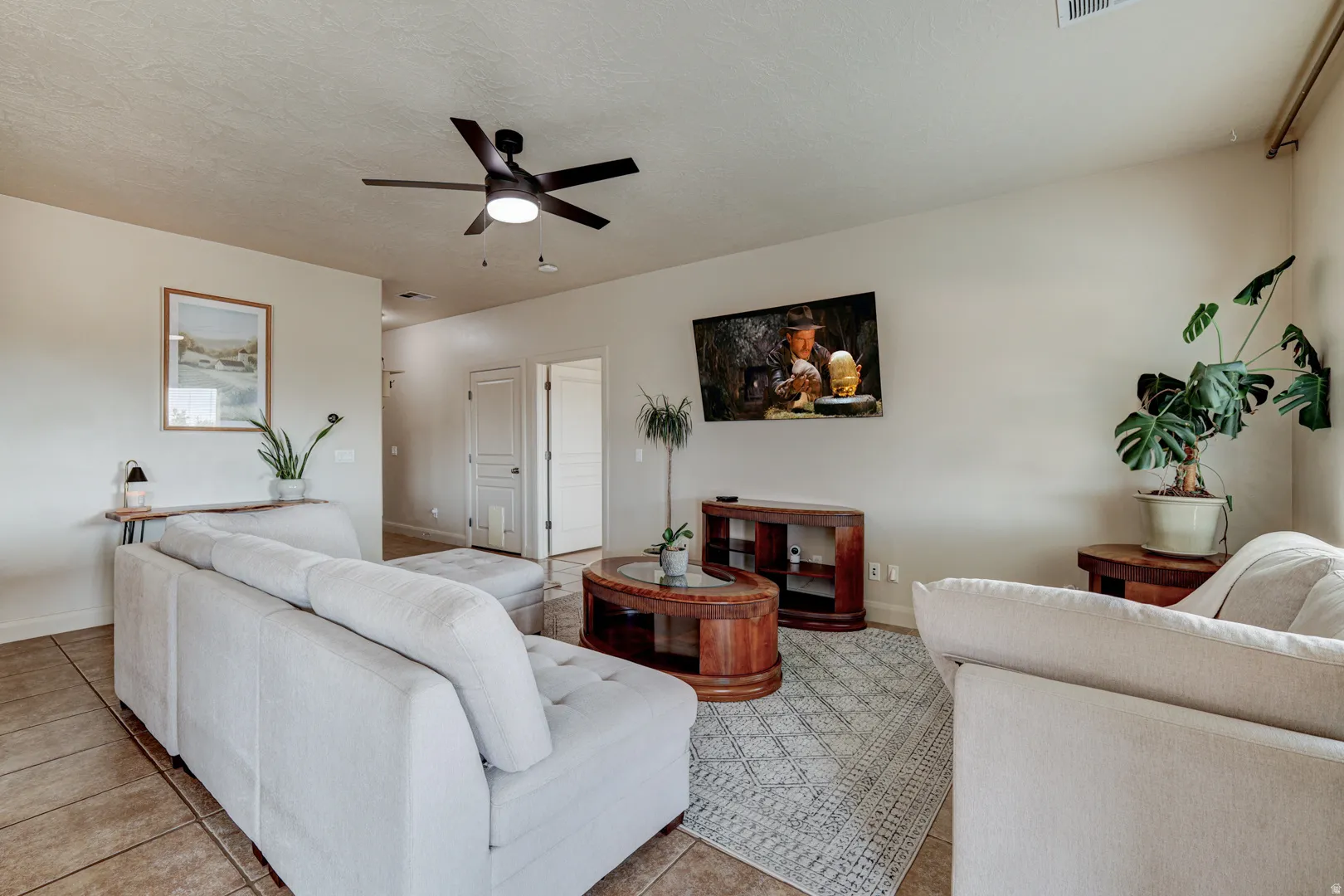 Neutral wall paint, tiled flooring, and a ceiling fan with integrated lighting