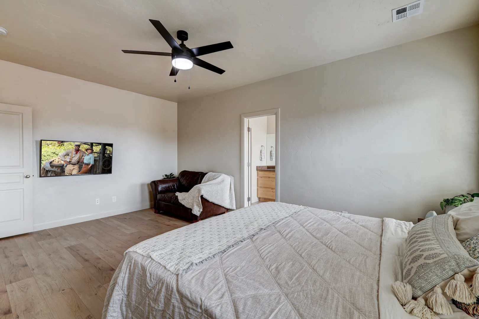Light wood-finish flooring, recessed lighting, and a ceiling fan with integrated lighting