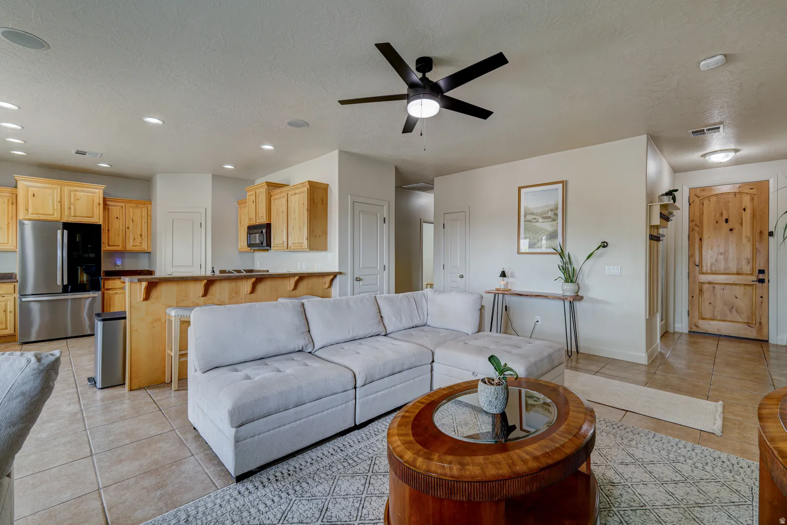 Open-concept living space with tile flooring, recessed lighting, and a ceiling fan
