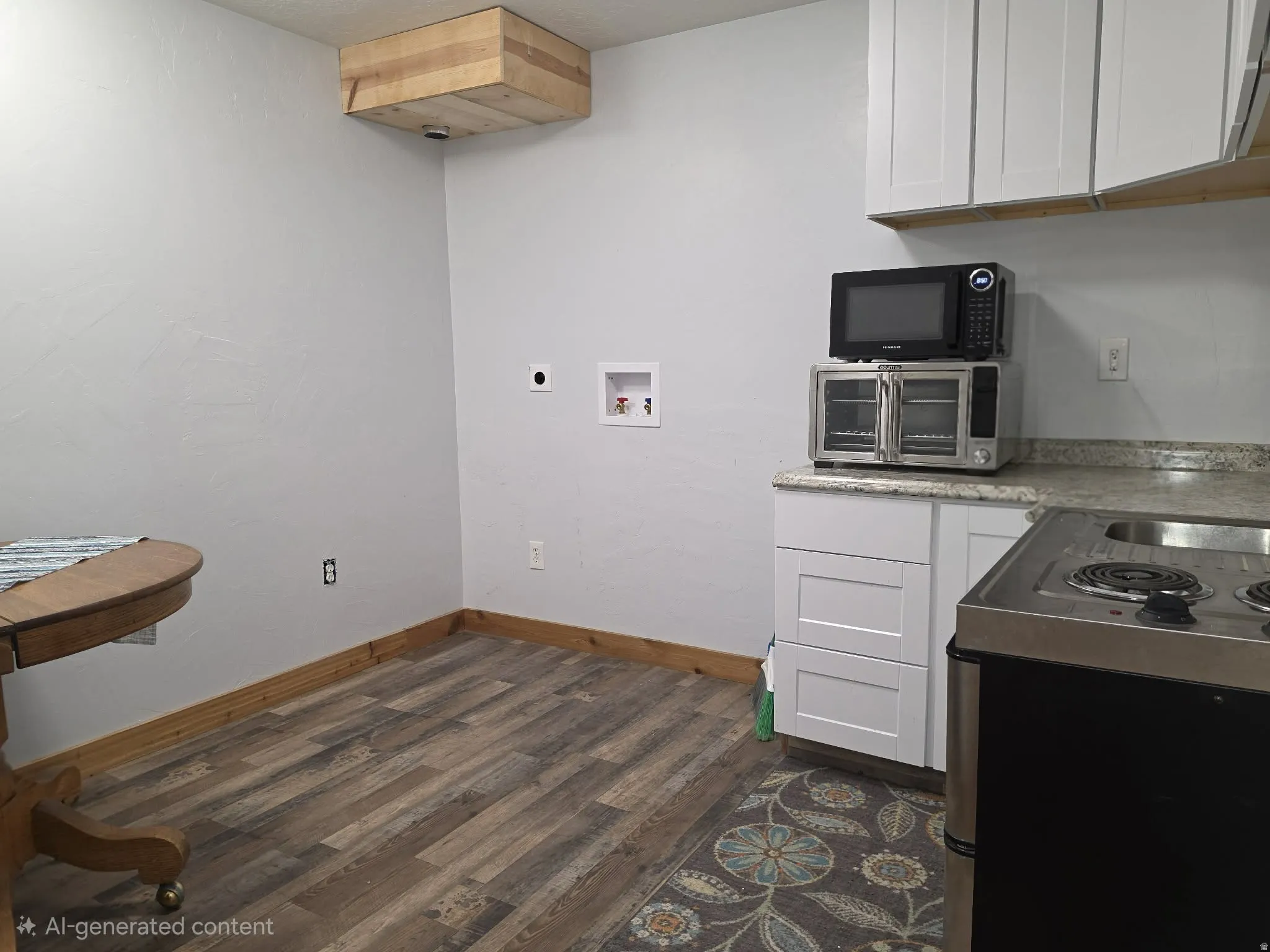 Wood-finish flooring, white cabinetry, and a light-colored countertop