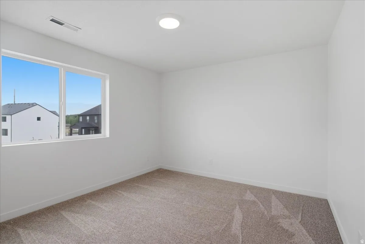 Recessed ceiling light with a window, white walls, and carpet flooring