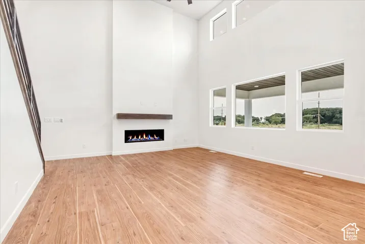 Great Room with Two-Story vaulted ceiling and Windows.   LVP lis more neutral in person!