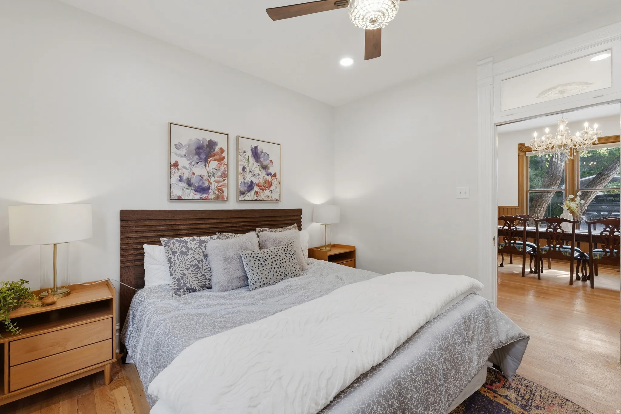 Hardwood flooring and a ceiling fan with a decorative light fixture enhance this room