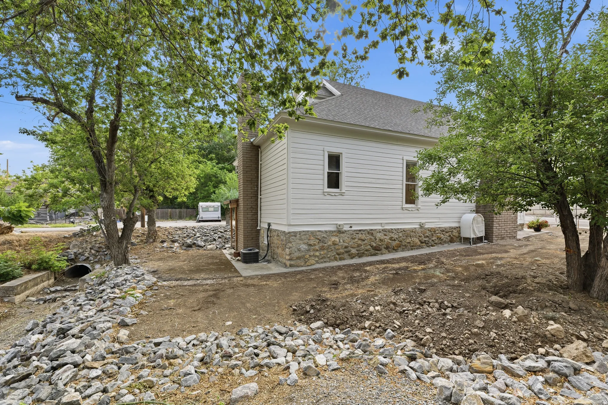 White siding exterior with a stone foundation