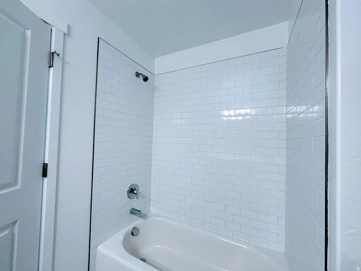 Bathtub and shower combination with subway tile surround and chrome fixtures