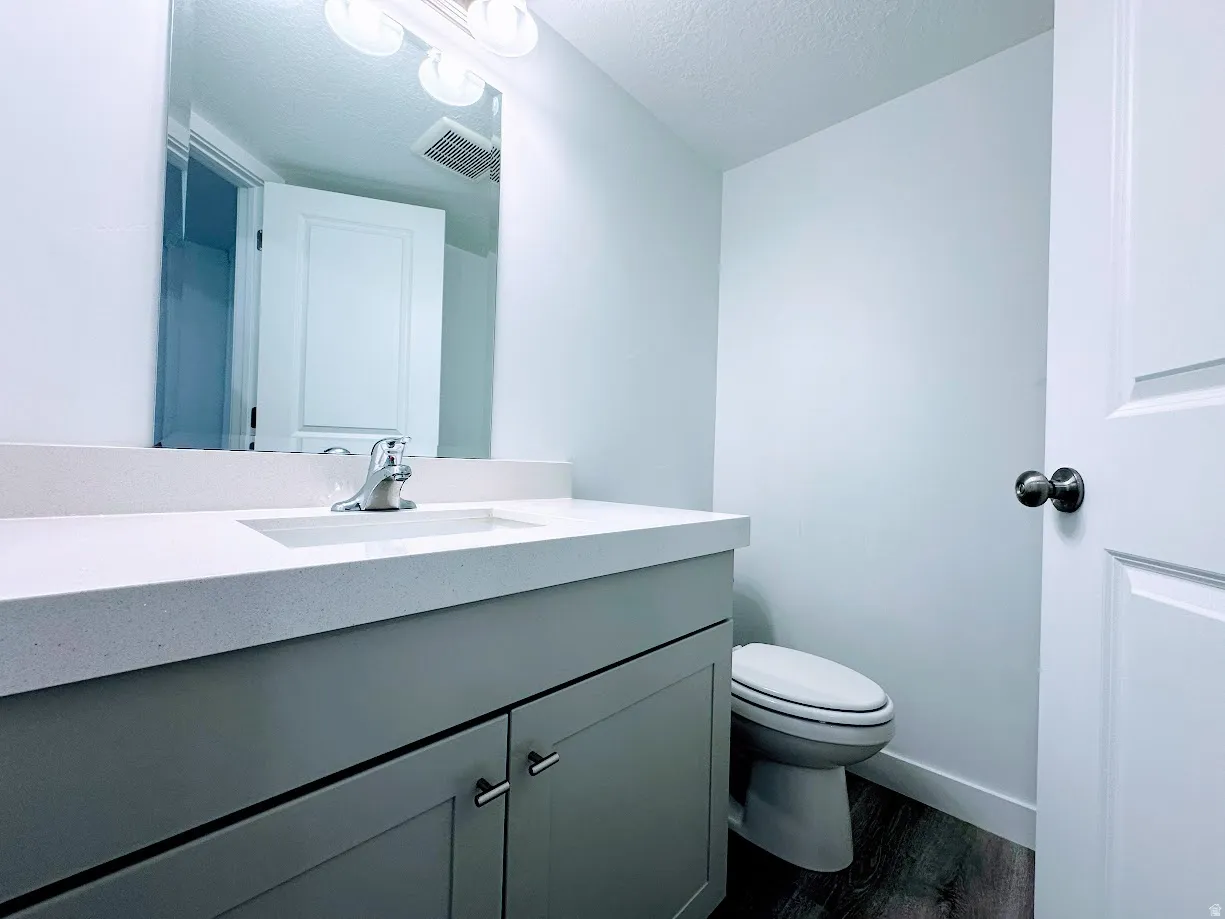 Contemporary bathroom featuring a gray vanity with dual drawers and polished chrome hardware, white quartz countertop, single-basin sink with chrome faucet, and ceramic tile flooring