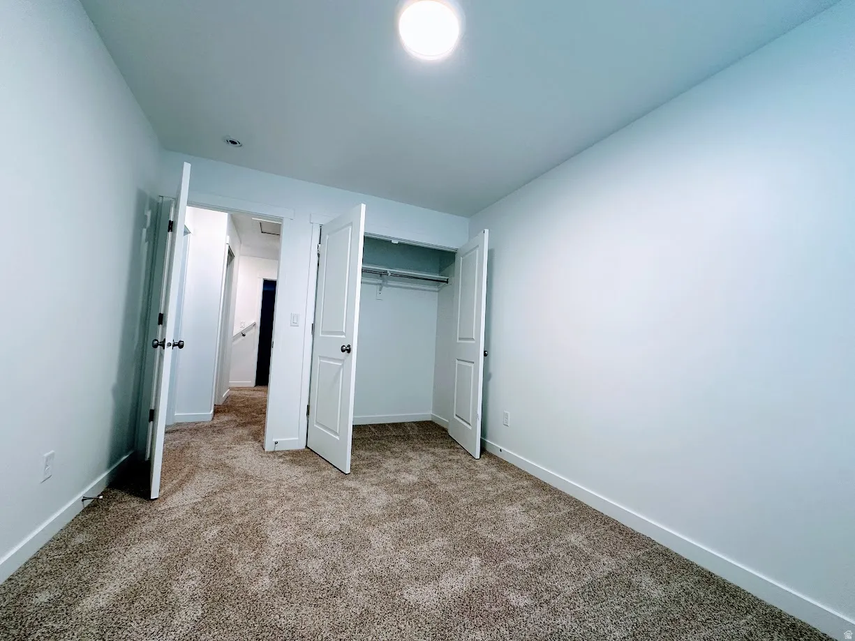 Spacious bedroom with neutral wall finishes, recessed ceiling lighting, and multiple closet spaces with white six-panel doors