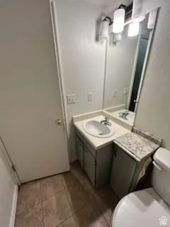 Bathroom featuring a single vanity with built-in cabinetry, an integrated sink, and a wall-mounted mirror