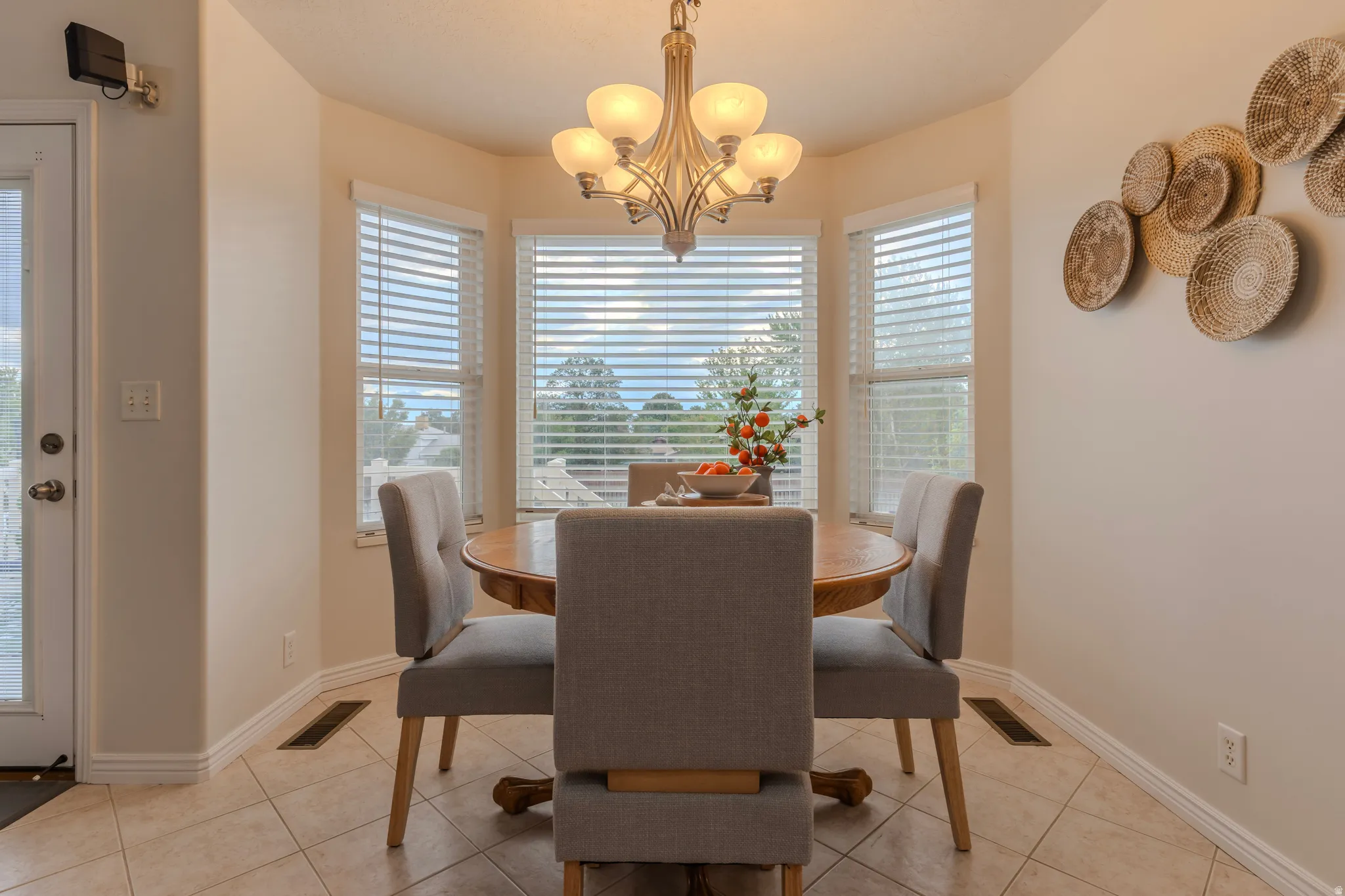 Elegant dining room bathed in natural light through triple arched windows with plantation shutters
