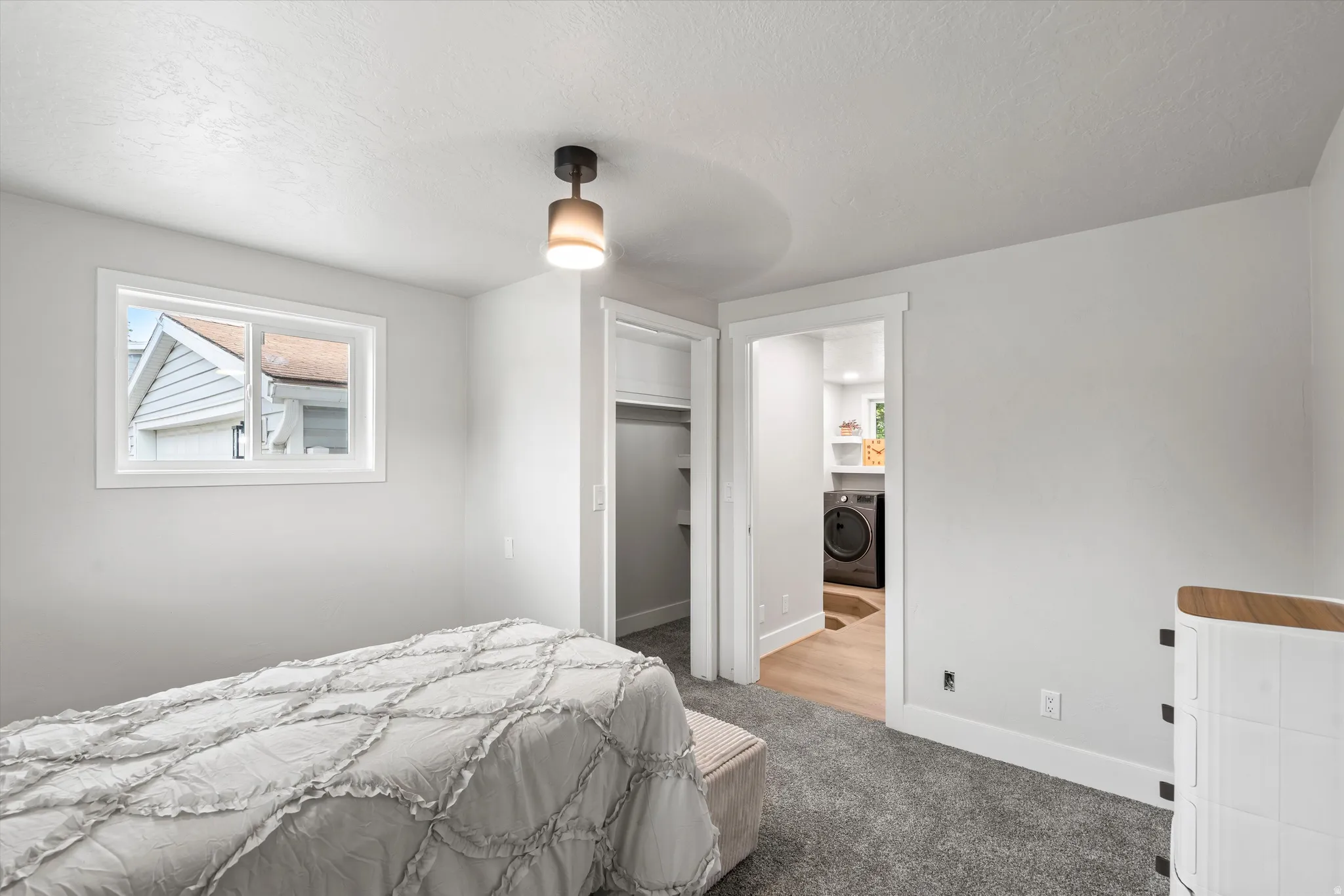 Recessed window with white trim, modern ceiling light fixture, white walls, and gray carpet