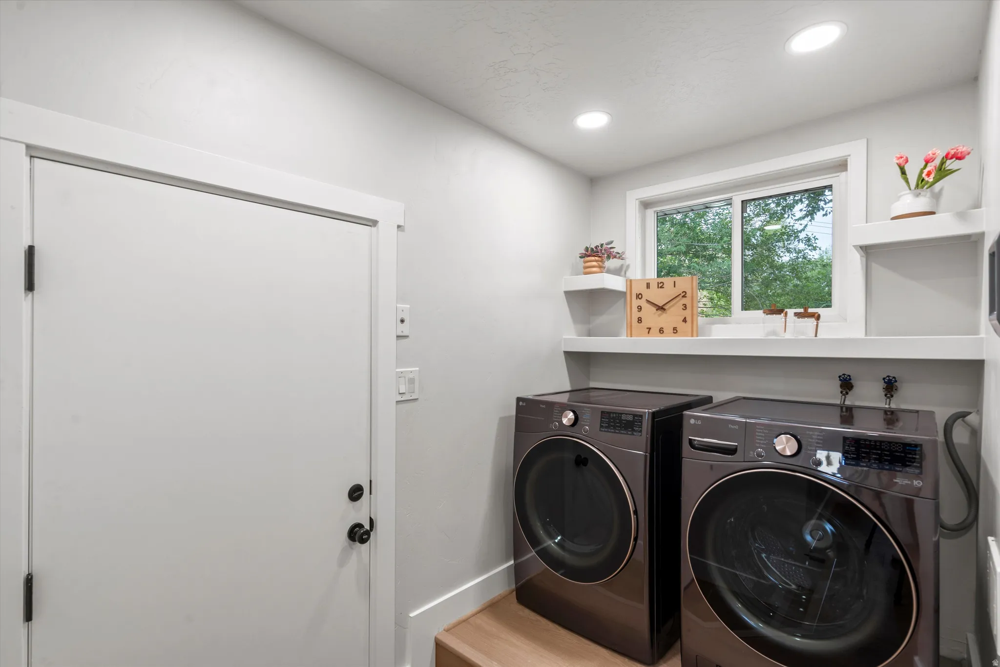Laundry area featuring a window, built-in shelving, recessed lighting, and wood-finish flooring