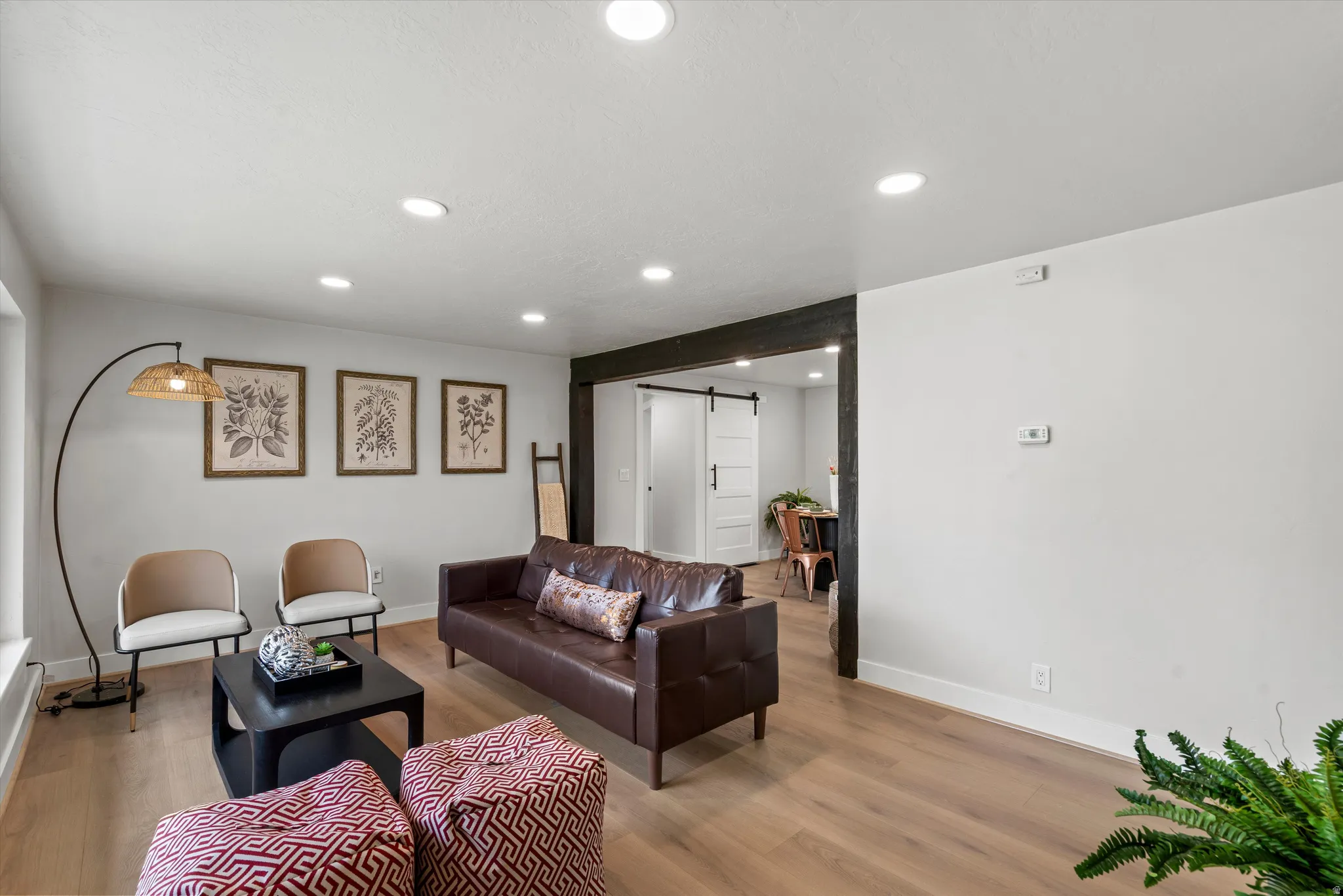 Recessed lighting, wood-finish flooring, and a dark-stained wood beam